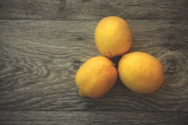 Hafif ahşap masa üstüne üç limon