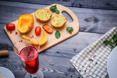 Bir beyaz tabak, çatal, kabak, patates, baharat ve kiraz domates fırında dilim yanında keten damalı peçete pişmiş havuç dilimleri ile bir parça et baharatlarla serpilir, pişmiş.