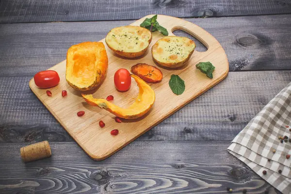 Kabak, havuç ve patates, domates ve nane hafif kesme tahtası, çatal bir koyu gri masa üstü arka plan üzerinde pişmiş dilim