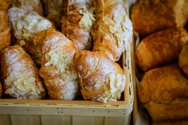 Taze pişmiş kruvasanlar beyaz toz ve fındık serpilir.