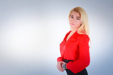 Beyaz ışık Mavi degrade arka plan için. Karnına katlanmış Kırmızı bluz elinde bize görünüyor.