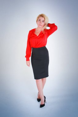 Beyaz ışık Mavi degrade arka plan için. Bir kız kırmızı bir bluz ve siyah bir etek sol eliyle saçlarını düzeltiyor.