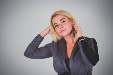 Beyaz ışık gri degrade arka plan. Gri ofis takım elbiseli bir kız chesshouse kamera saçlarını düzeltiyor.