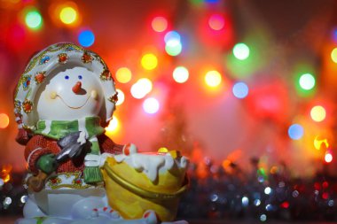 Mutlu yeni yıl tebrik kartı için arka plan. Kardan adam şamdan garland ve tinsel parlak renkli ışıklar arka plan üzerinde.