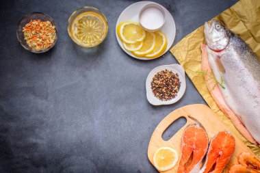 Çiğ balık ile baharat. RAW ağır Kraft kağıt üzerinde gri bir masa üstü limon böyle çiğ balık yağı tuz ile limon dilimleri baharat biber.