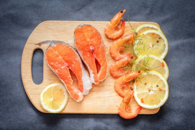 Çiğ balık ile baharat. Tatlı limon dilimi gri kurnaz masa üstü ahşap tahta üzerine doğranmış somon.