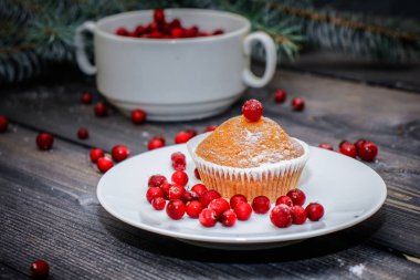 Festival bileşimi yılbaşı Kartpostal arka plan için. Hangi yalan üzerine taze Ladin bir bardak taze çilek ile bir kırmızı beyaz tabak taze pişmiş kek ile dalları bir ışık gri ahşap masa üstü kırmızı meyveler ile dekore edilmiş ve pudra şekeri.