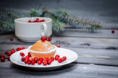Festival bileşimi yılbaşı Kartpostal arka plan için. Hangi yalan üzerine taze Ladin bir bardak taze çilek ile bir kırmızı beyaz tabak taze pişmiş kek ile dalları bir ışık gri ahşap masa üstü kırmızı meyveler ile dekore edilmiş ve pudra şekeri.