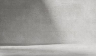 Çimento duvar desenli gri arkaplan. Pencereden yumuşak gölgeler görünen ürün sunumları için minimalist soyut arkaplan