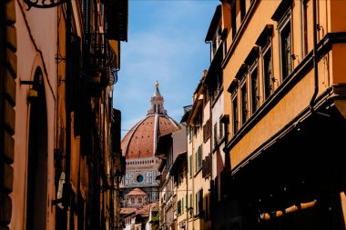 FLORENCE, ITALY - JULY 17, 2017: narrow street and famous Basilica di Santa Maria del Fiore in Florence, Italy   clipart