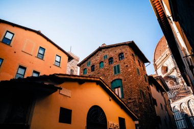 cozy narrow street with old historic buildings in florence, italy  clipart