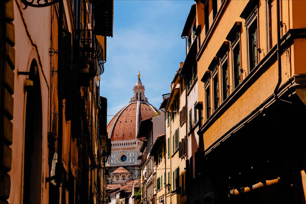 FLORENCE, ITALY - JULY 17, 2017: narrow street and famous Basilica di Santa Maria del Fiore in Florence, Italy  