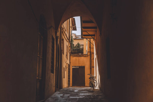 арка в старинных зданиях с велосипедом, Пиза, Италия
 