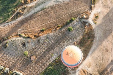 top view of hot air balloon flying above majestic landscape in cappadocia, turkey  clipart