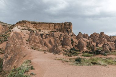 beautiful eroded rock formations at cloudy day, cappadocia, turkey  clipart