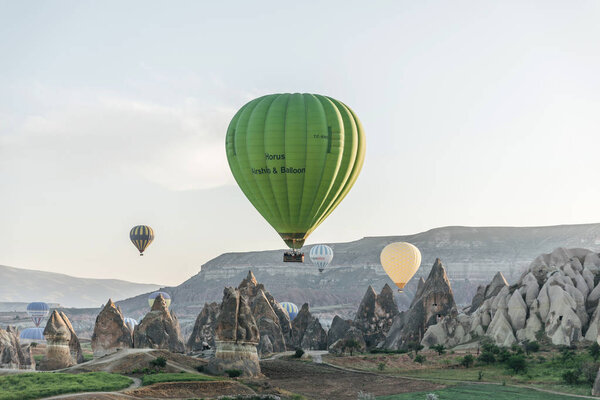 CAPPADOCIA, TURKEY - 09 MAY, 2018: hot air balloons flying above beautiful rock formations in goreme national park, cappadocia, turkey         
