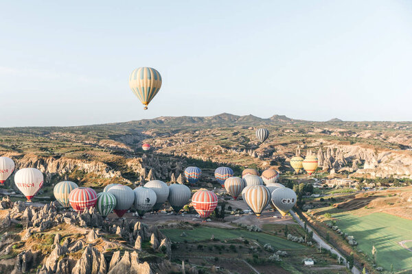 CAPPADOCIA, TURKEY - 09 MAY, 2018: hot air balloons flying above beautiful landscape in goreme national park, cappadocia, turkey        