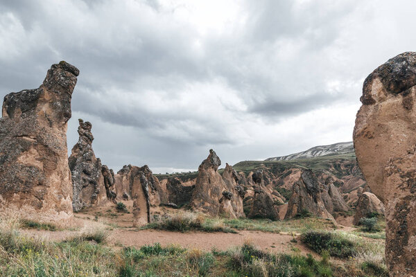 bizarre rock formations against cloudy sky in cappadocia, turkey