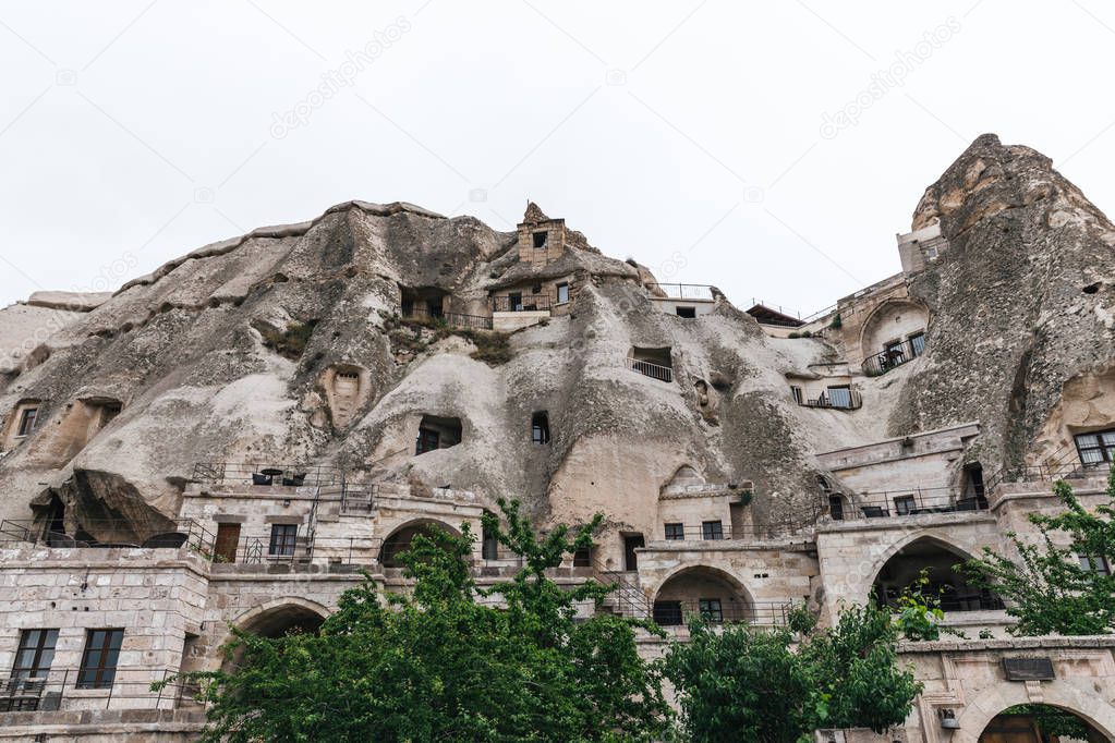 low angle view of beautiful rock formations and buildings in cappadocia, turkey