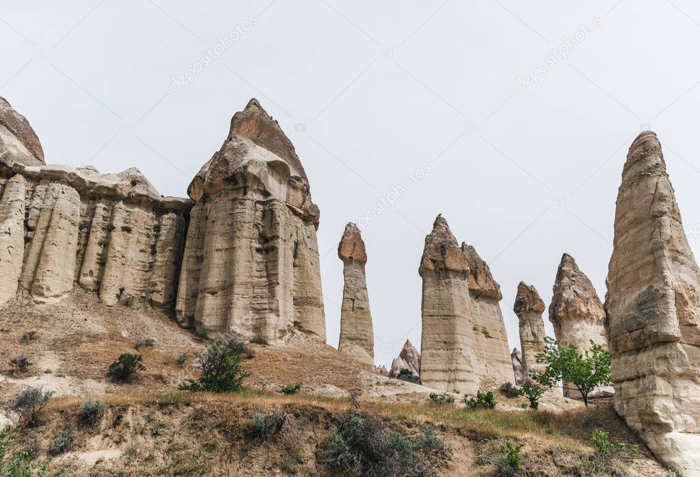 majestic rock formations against cloudy sky in famous cappadocia, turkey 