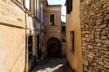 cozy narrow street with old stone buildings in provence, france clipart
