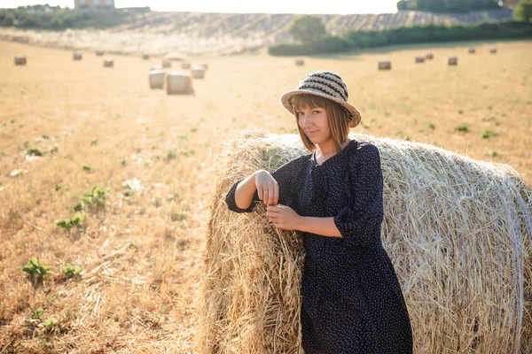 美丽的年轻女子倚在干草包和看相机 普罗旺斯 — 图库照片