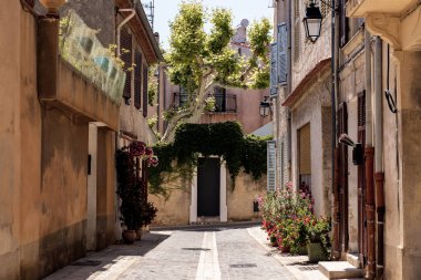 cozy narrow street with traditional houses and blooming flowers in pots, provence, france clipart