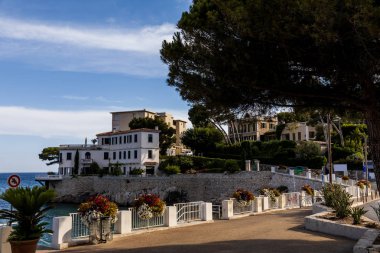 empty embankment and beautiful houses at sea coast in provence, france clipart