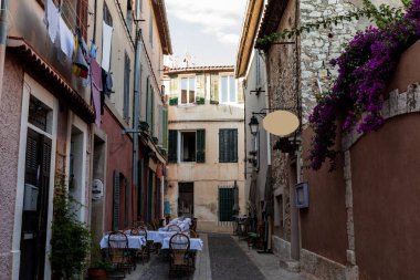 cozy narrow street with traditional houses and outdoor cafe in provence, france clipart