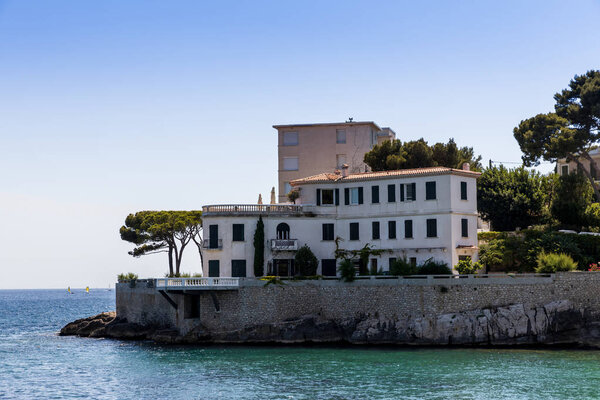 традиционные дома и зеленые деревья на скалистом побережье моря в провинции, Франция
