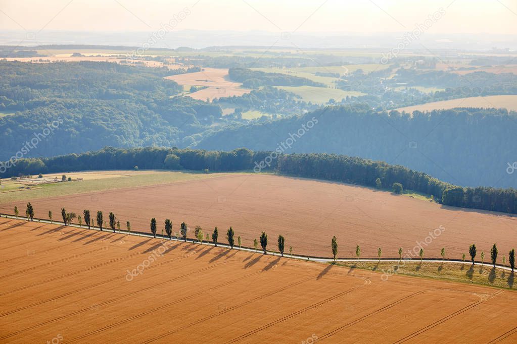 aerial view of beautiful orange fields with harvest, hills and road in Bad Schandau, Germany