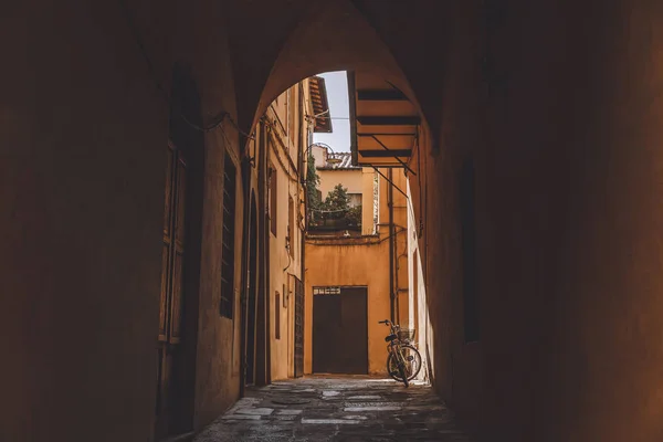 Arco em edifícios antigos com bicicleta, Pisa, Itália — Fotografia de Stock