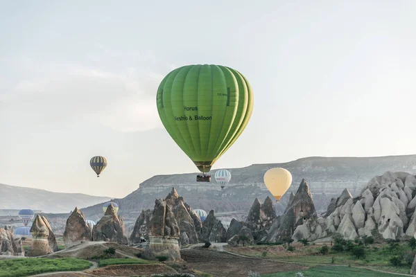CAPPADOCIA, TURKEY - 09 MAY, 2018: hot air balloons flying above beautiful rock formations in goreme national park, cappadocia, turkey — Stock Photo