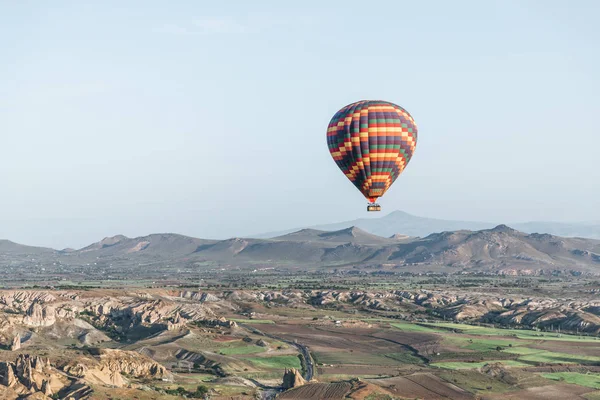 Globo de aire caliente colorido que vuela sobre el parque nacional del goreme, capadocia, pavo - foto de stock