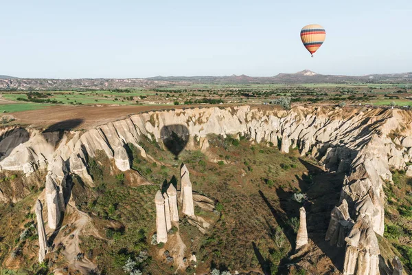 Single hot air balloon flying above beautiful famous rock formations in cappadocia, turkey — Stock Photo