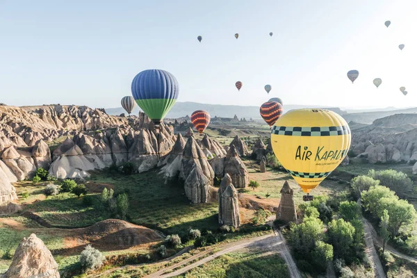 CAPPADOCIA, TURQUÍA - 09 MAY, 2018: globos de aire caliente de colores volando en el cielo por encima del famoso parque nacional de goreme, capadocia, pavo - foto de stock