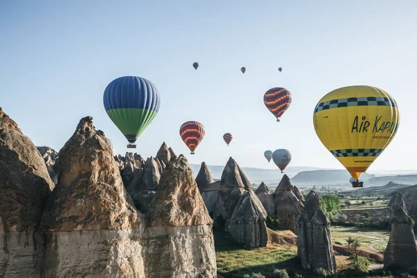 CAPPADOCIA, TURQUIE - 09 MAI 2018 : montgolfières volant dans le ciel au-dessus de formations rocheuses majestueuses dans la célèbre cappadoce, dinde — Photo de stock