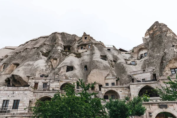 Низкоугловой вид на красивые скальные образования и здания в Каппадокии, индейка — стоковое фото