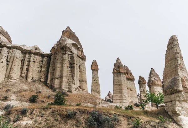 Formations rocheuses majestueuses contre ciel nuageux en célèbre cappadoce, dinde — Photo de stock