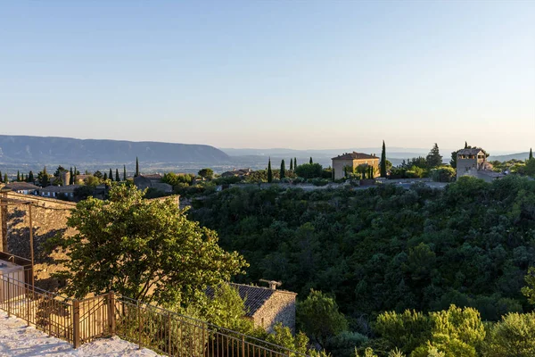 Vue panoramique sur les maisons traditionnelles, la végétation verte et les montagnes lointaines en provence, France — Photo de stock