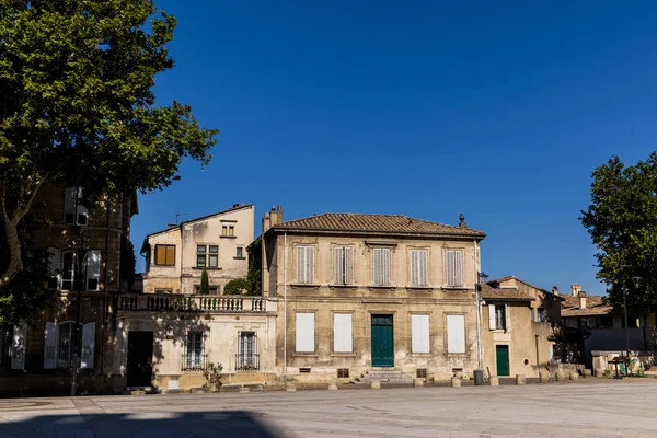 Calle vacía con viejas casas tradicionales y árboles verdes en el día soleado, provence, francia - foto de stock