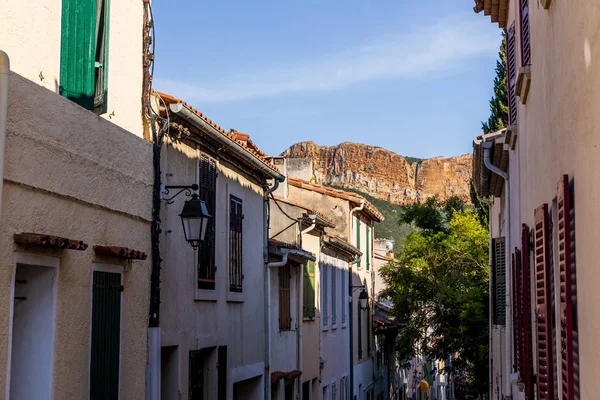 Rue étroite confortable avec maisons traditionnelles et montagnes rocheuses lointaines en provence, france — Photo de stock