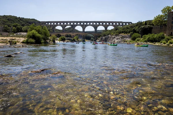 PROVENCE, FRANCIA - 18 DE JUNIO DE 2018: Pont du Gard (puente sobre Gard) y personas nadando en barcos en Provenza, Francia - foto de stock