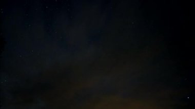 Yıldızlı gökyüzüne karşı hareketli bulutlar.