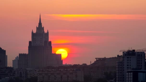 Hinter einem Gebäude in der Stadt geht die Sonne auf. 4k uhd Zeitraffer. — Stockvideo