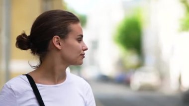 Şehirde güzel bir kız etrafa bakıyor. Portre. El bilgisayarı Çekimi