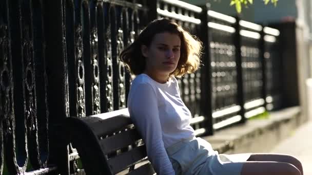 美しい少女が街のベンチに腰を下ろして — ストック動画