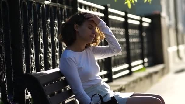 美しい少女が街のベンチに腰を下ろして — ストック動画