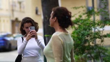 Annesinin akıllı telefonunu kullanarak video çeken güzel bir kız..