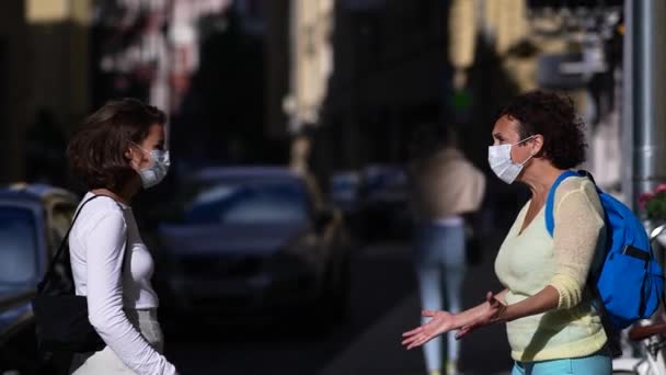 医療マスクの2人の女性が市内で会う。携帯電話を見ながら女の子の感情. — ストック動画